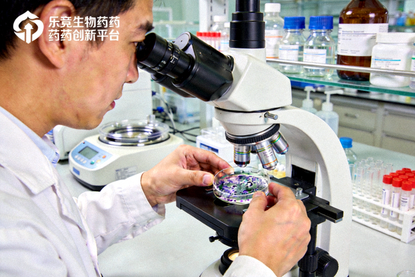 乐竟生物药创新平台实验室中研究人员正在使用显微镜观察细胞样本